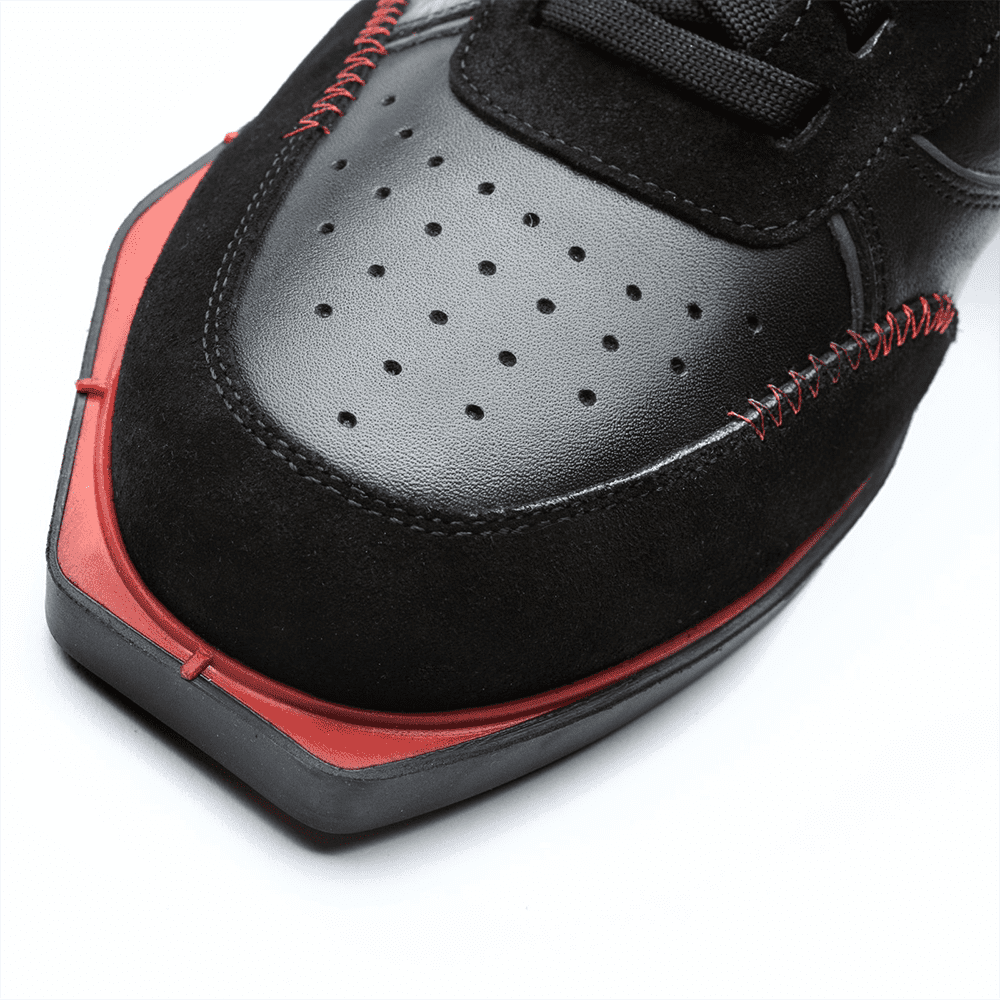 20101001-00_Triple20_Dartschuhe_Leder_Schwarz_Rot_4 Der Schuh besteht aus schwarzem Leder mit roten Akzenten und auffälligen roten Nähten. Die Schuhspitze ist kantig geformt und hat kleine Belüftungslöcher.