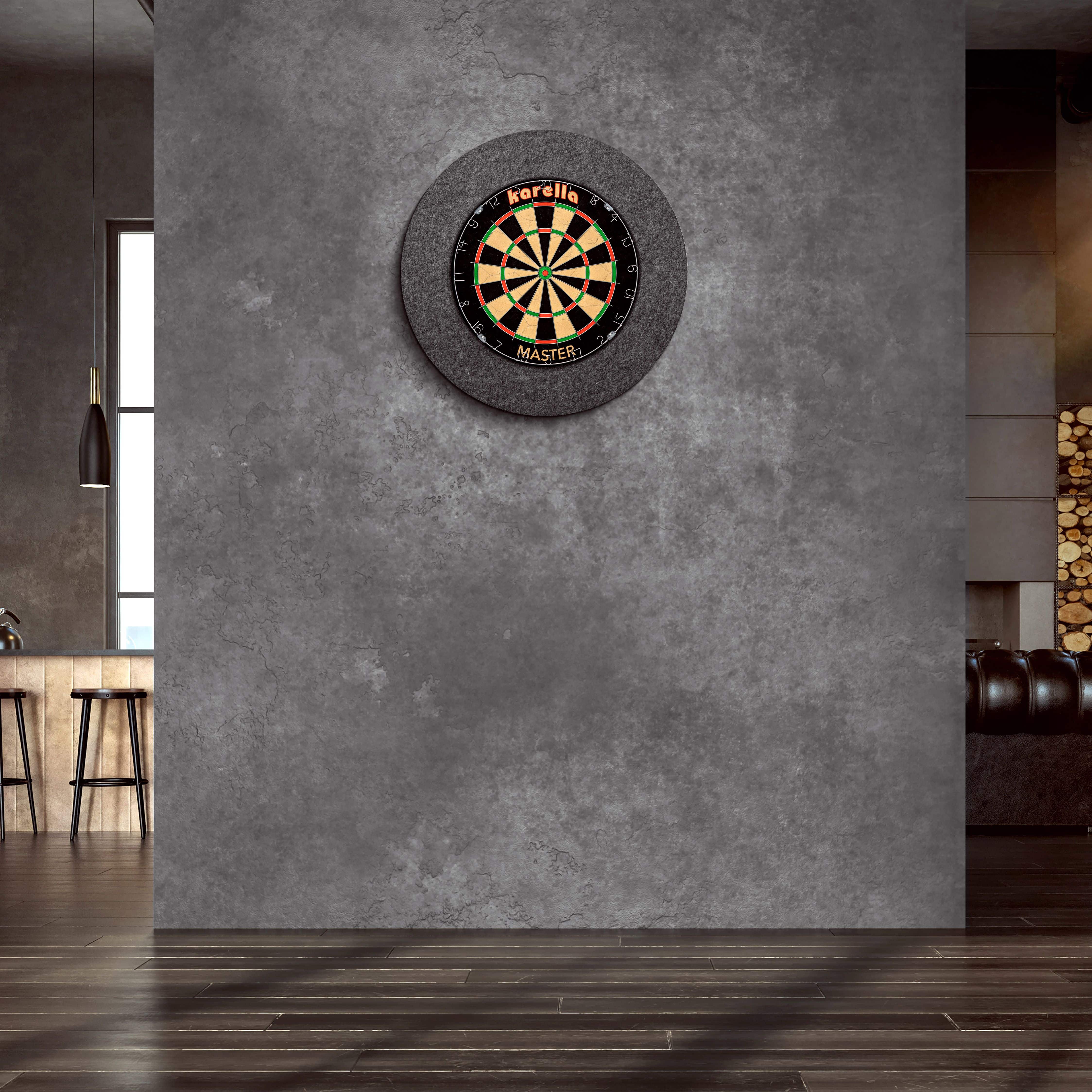 Cadre de cible en acier Karella Ultimo An der Wand hängt ein "Karella Ultimo Steeldartboard Surround". Der Raum wirkt modern und stilvoll mit dunklen Farben und eleganter Einrichtung.