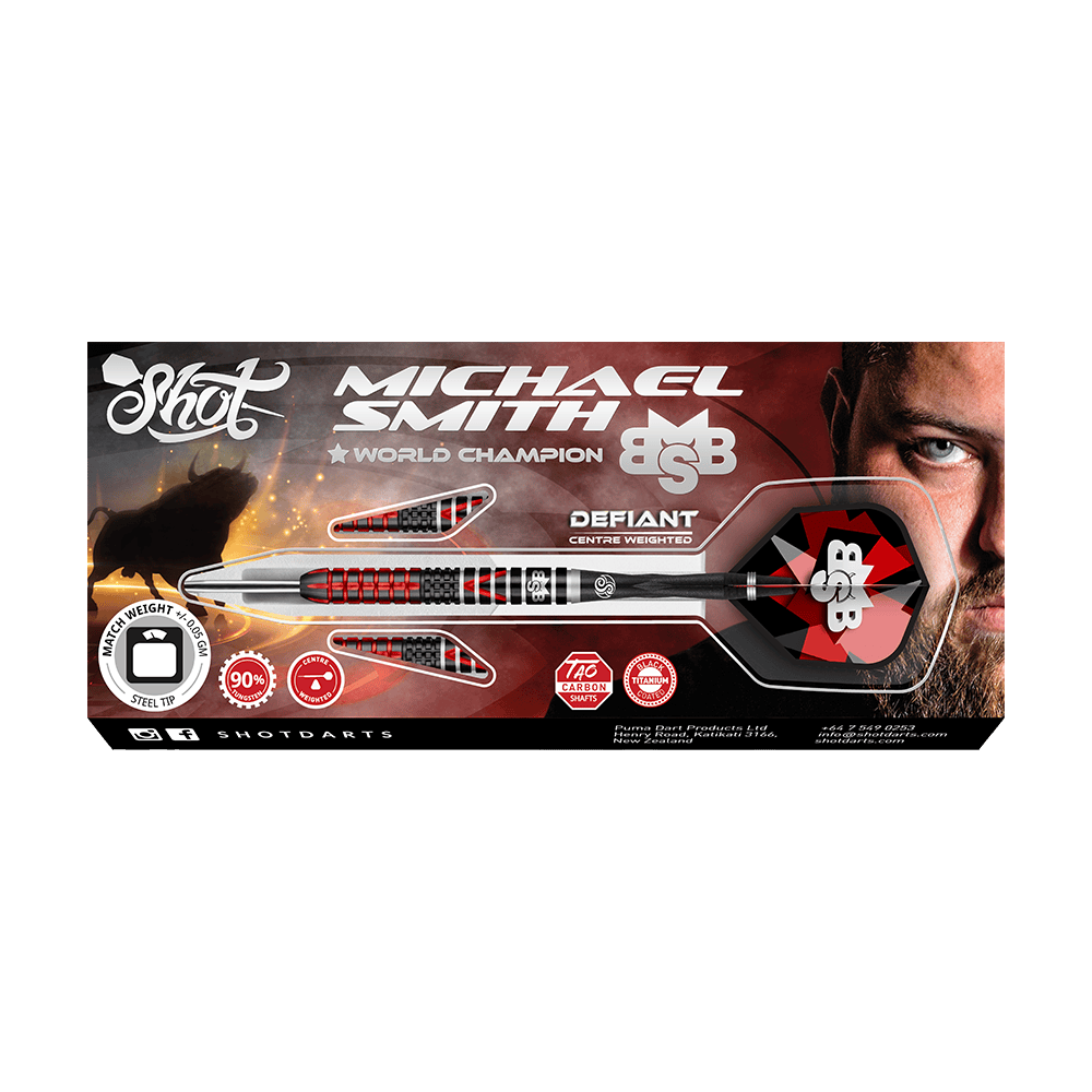 Shot Michael Smith Defiant Steeldarts Das Bild zeigt die Verpackung der "Shot Michael Smith Defiant Steeldarts". Auf der Schachtel ist ein Dartpfeil zusammen mit dem Bild eines Mannes und verschiedenen Informationen zum Produkt abgebildet.