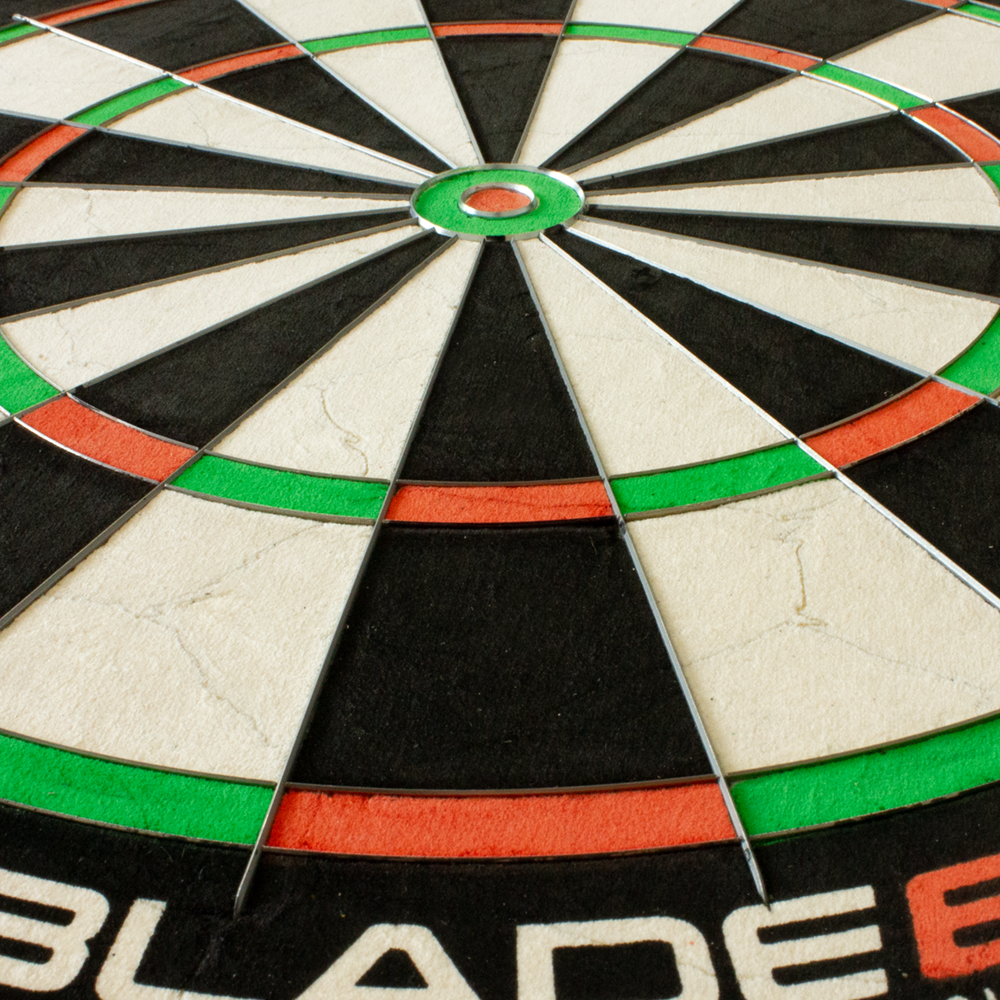 3033_Winmau_Blade_6_Steeldartboard_4 Das Bild zeigt eine Nahaufnahme eines Winmau Blade 6 Steeldartboards. Die bunten Felder und die dünnen Metallspinnen sind deutlich zu erkennen.