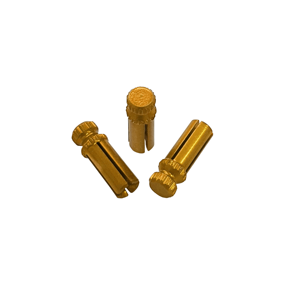 Das Bild zeigt drei goldfarbene Alu Flightschoner. Sie sind kleine, zylindrische Schutzkappen für Dart-Flights.