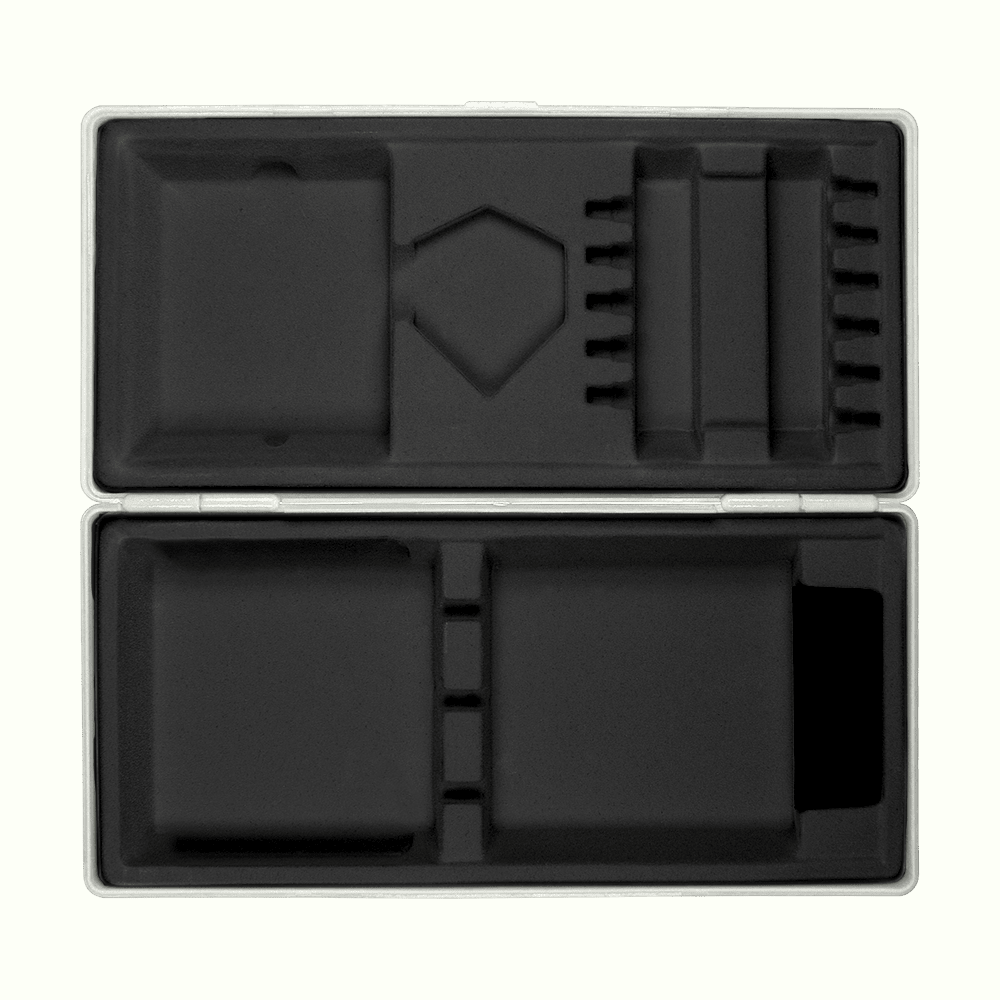 Boîte en ABS avec impression personnalisée Die Abbildung zeigt eine geöffnete graue Box mit passgenauen Fächern aus schwarzem Schaumstoff. Die Box liegt auf einem hellgelben Hintergrund.