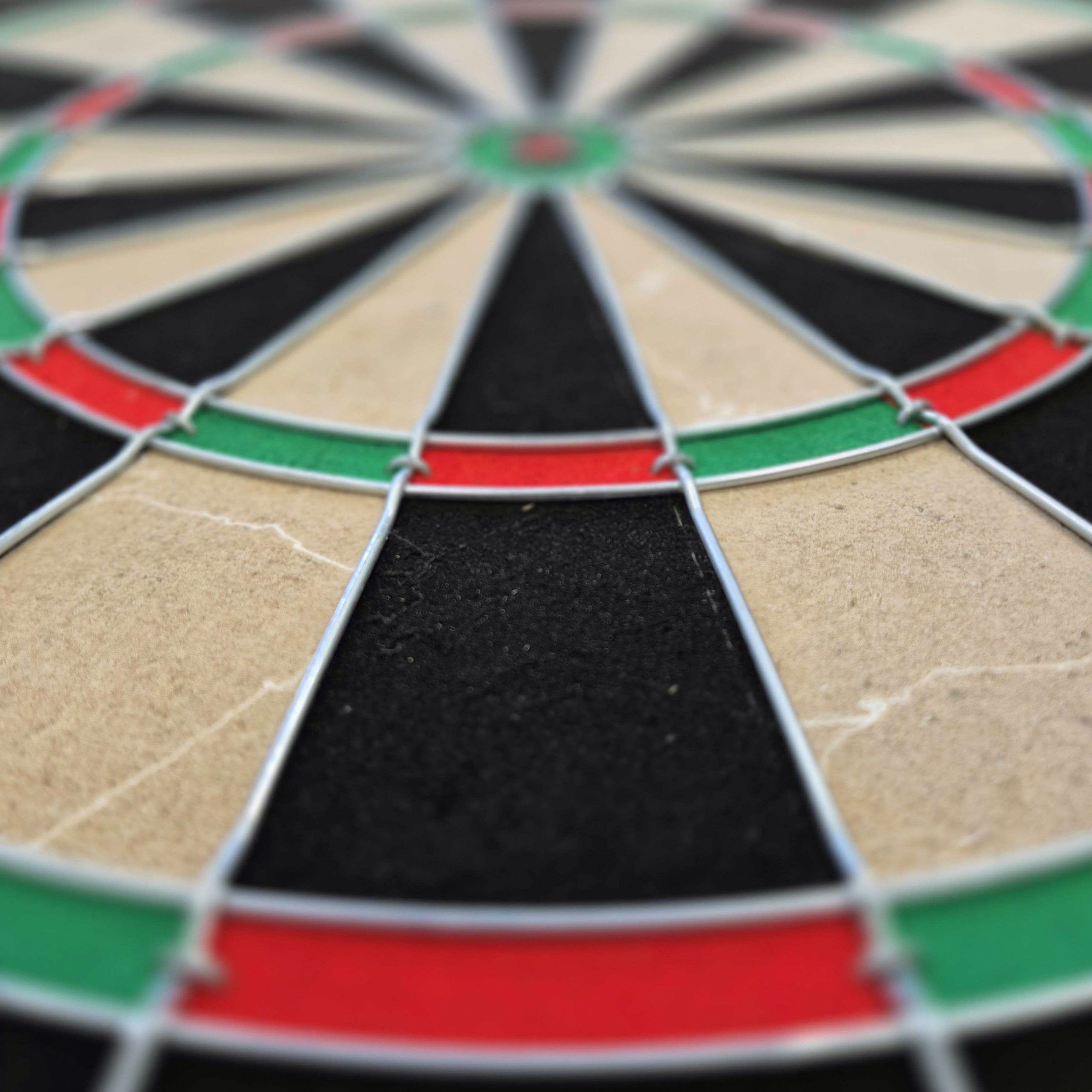 Jeu de fléchettes en acier Target Gabriel Clemens Das Bild zeigt ein Steeldartboard mit farbigen Segmenten in Rot, Grün, Schwarz und Beige. Es handelt sich um das Produkt "Target Gabriel Clemens Steeldartboard Set".