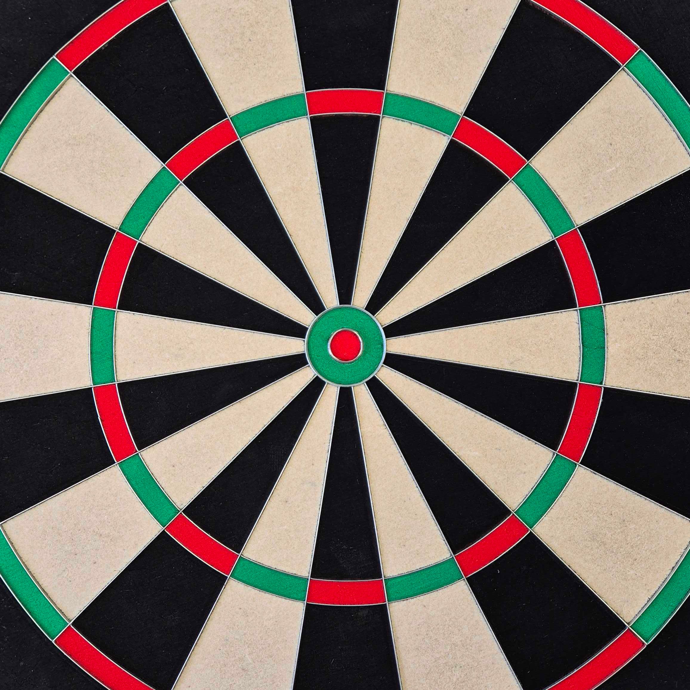 Cible de fléchettes en acier McDart Precision Das Bild zeigt ein McDart Precision Steeldartboard. Die Dartscheibe ist in schwarze, beige, grüne und rote Segmente unterteilt.