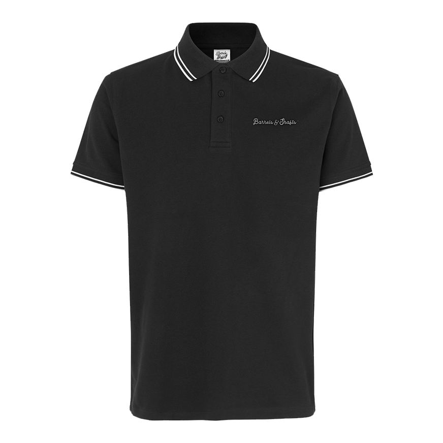 Polo Barrels and Shafts - Noir Das Bild zeigt ein schwarzes Poloshirt mit weißen Akzenten an Kragen und Ärmeln. Auf der Brust ist der Schriftzug "Barrels & Shafts" eingestickt.