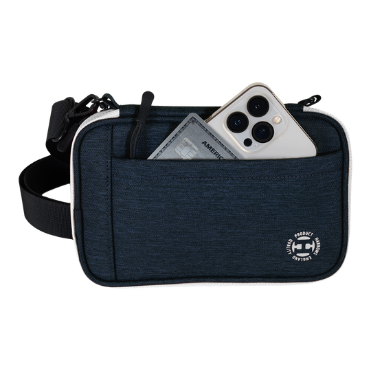Portefeuille à fléchettes Harrows Smart Case XL Eine blaue Tasche mit Vorderfach enthält ein Smartphone und eine Kreditkarte. Am unteren Rand der Tasche befindet sich ein rundes weißes Logo.