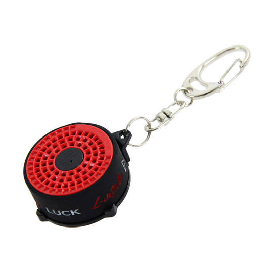 LSF18_L-Style_Bull_Spitzen-und-Shaftrestentferner_1 Das Bild zeigt den "L-Style BULL Spitzen- und Shaftrestentferner" mit einem Schlüsselanhänger. Das Produkt ist rund, überwiegend schwarz mit einer roten Oberseite.