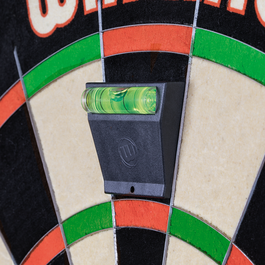 3032_Winmau_Blade_6_TripleCore_Steeldartboard_5tLvtGjToCdEWS Das Bild zeigt ein Detail des Winmau Blade 6 TripleCore Steeldartboards mit einer Wasserwaage zur Ausrichtung. Die bunten Segmente des Dartboards sind deutlich zu erkennen.