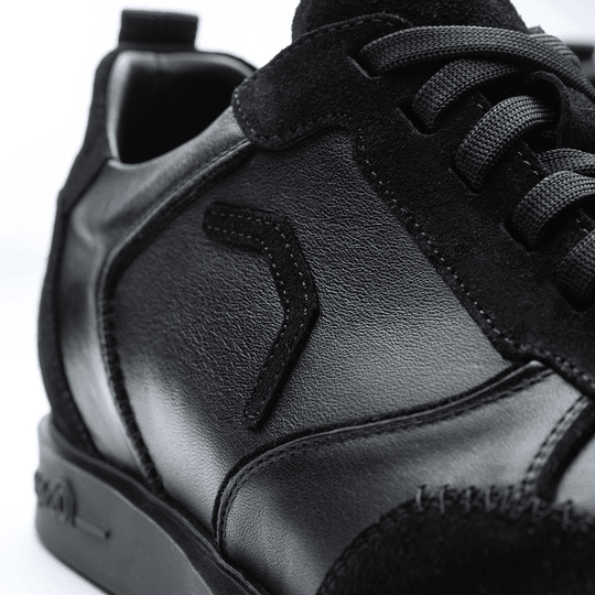 20100006-00_Triple20_Dartschuhe_Leder_Schwarz_5 Der Schuh „Triple20 Dartschuhe Leder - Schwarz“ ist aus schwarzem Leder gefertigt und hat schwarze Schnürsenkel. Die Nahaufnahme zeigt die hochwertige Verarbeitung und das dezente Design.