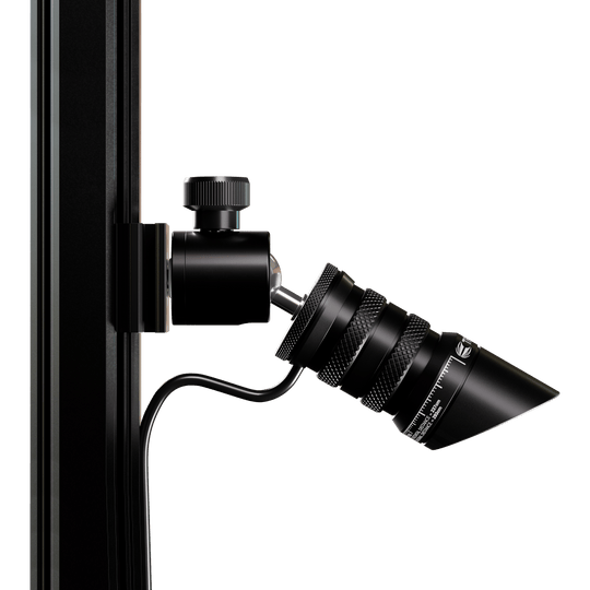 Das Bild zeigt das Produkt "Target MOD Laser Oche", das an einer vertikalen Stange befestigt ist. Es handelt sich um ein schwarzes, zylindrisches Gerät mit einem Kabelanschluss und feinen Details.