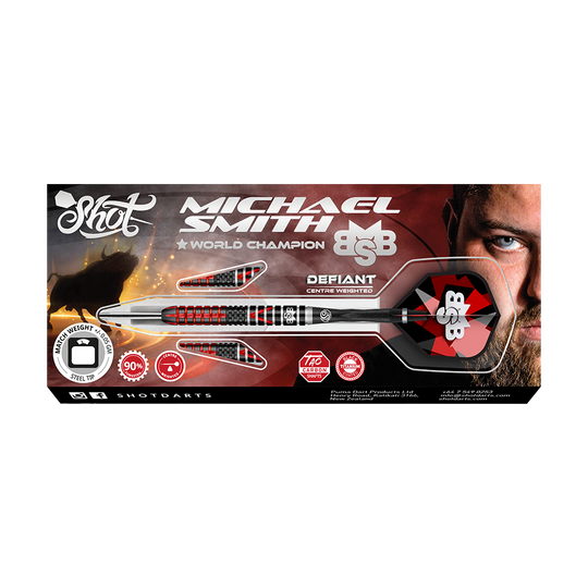 Shot Michael Smith Defiant Steeldarts Das Bild zeigt die Verpackung der "Shot Michael Smith Defiant Steeldarts". Auf der Schachtel ist ein Dartpfeil zusammen mit dem Bild eines Mannes und verschiedenen Informationen zum Produkt abgebildet.