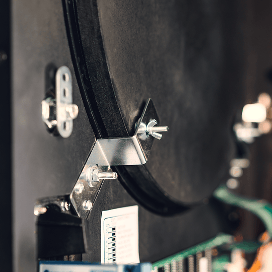Karella_E-Master_Dartautomat_Detail_Innenansicht_Az5JJqnA8xyX1m Das Bild zeigt einen Nahaufnahmebereich des Karella E-MASTER Dartautomaten ohne Münzeinwurf. Zu sehen sind Metallbefestigungen und elektronische Bauteile im Inneren des Geräts.