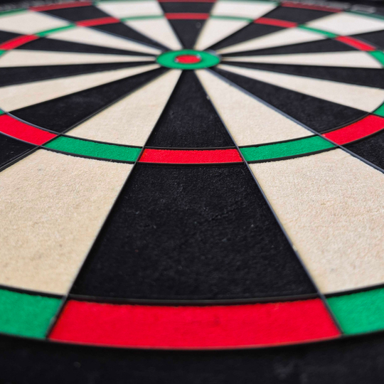 Cible de fléchettes en acier Unicorn Eclipse Ultra 2.0 Das Bild zeigt ein Unicorn Eclipse Ultra 2.0 Steeldartboard aus der Nähe. Die farbigen Felder in Rot, Grün, Schwarz und Weiß sind deutlich zu erkennen.