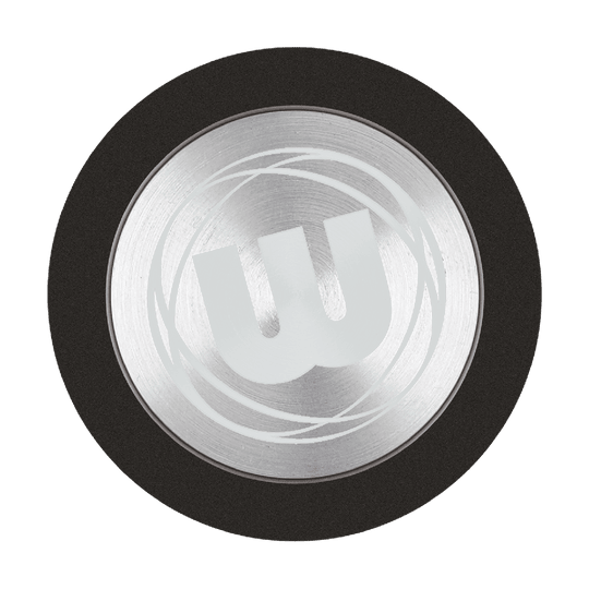 Das Bild zeigt den Winmau Premium Point Protector für Steeldarts. Es handelt sich um einen runden, silbernen Schutz mit einem großen "W"-Logo in der Mitte.