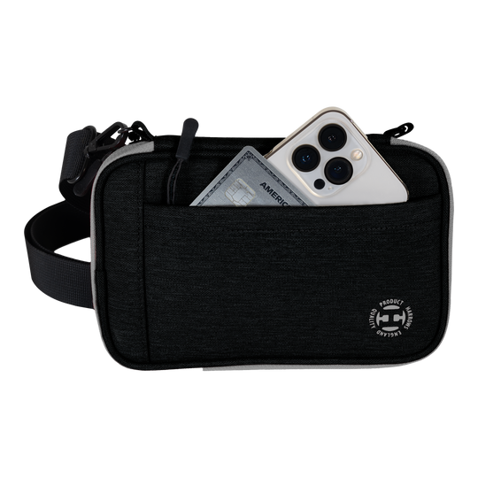 Portefeuille à fléchettes Harrows Smart Case XL Auf dem Bild ist eine schwarze Harrows Smart Case XL Darttasche zu sehen. In der vorderen Tasche stecken ein Smartphone und eine Kreditkarte.