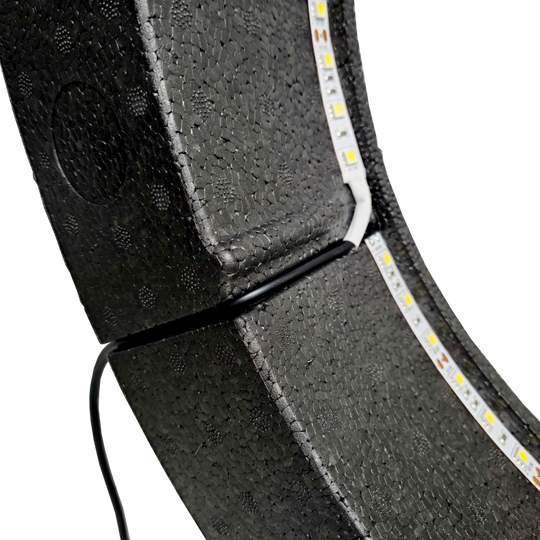 Système d'éclairage Bulls NL Lumo Light Surround Das Bild zeigt das „Bulls NL Lumo Light Surround Beleuchtungssystem“ mit LED-Leuchtstreifen auf einer schwarzen, strukturierten Oberfläche. Ein Kabel ist ebenfalls an das Beleuchtungssystem angeschlossen.