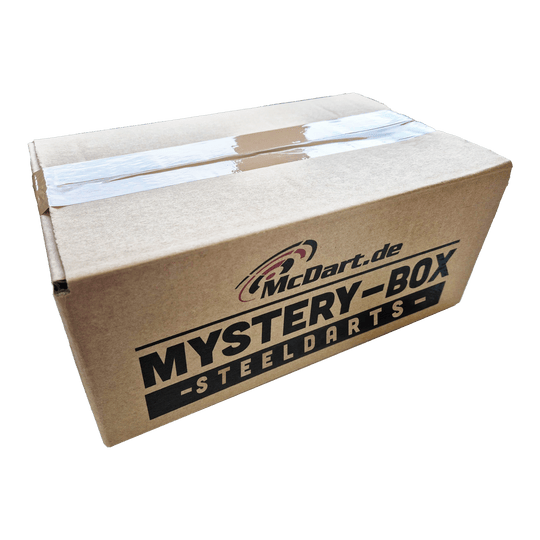 Boîte mystère de fléchettes souples Phil Taylor Auf dem Bild ist ein Karton mit der Aufschrift "McDart.de Mystery-Box Steeldarts" zu sehen. Die Box ist mit durchsichtigem Klebeband verschlossen.